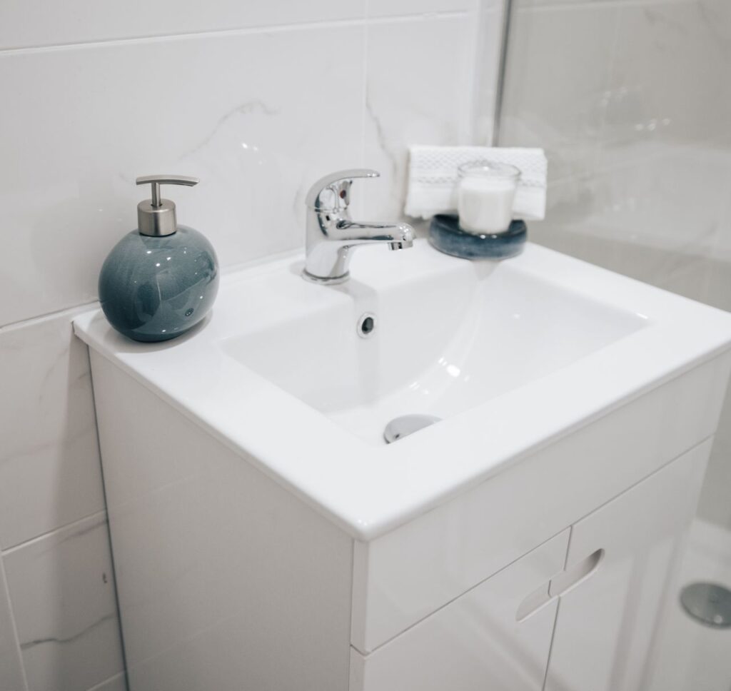 A clean and modern bathroom sink with a chrome faucet, soap dispenser, and towel for a fresh look.